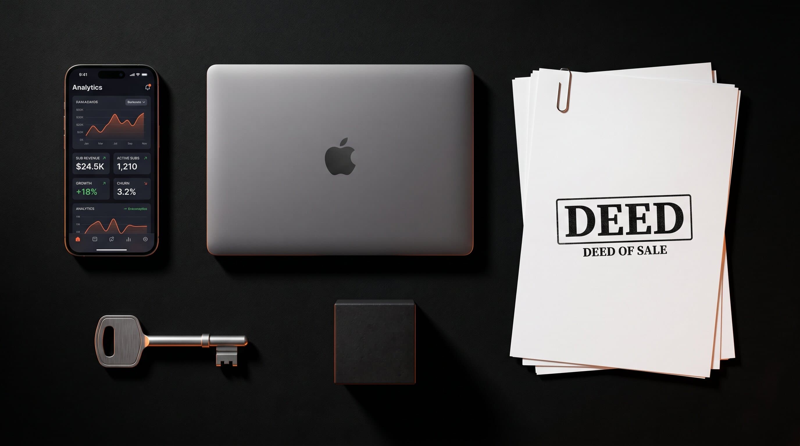 Overhead flat-lay showing the components of a sellable creator business: a smartphone with subscription analytics, a laptop, a deed of sale, a key, and a small black cube, lit with warm orange accents on a black surface
